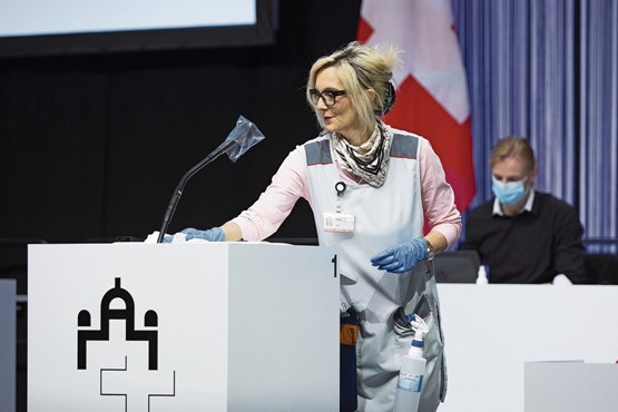 Propre en ordre: une employée de l’Office fédéral des constructions et de la logistique désinfecte un pupitre lors de la session spéciale du Parlement.	Photo: Keystone